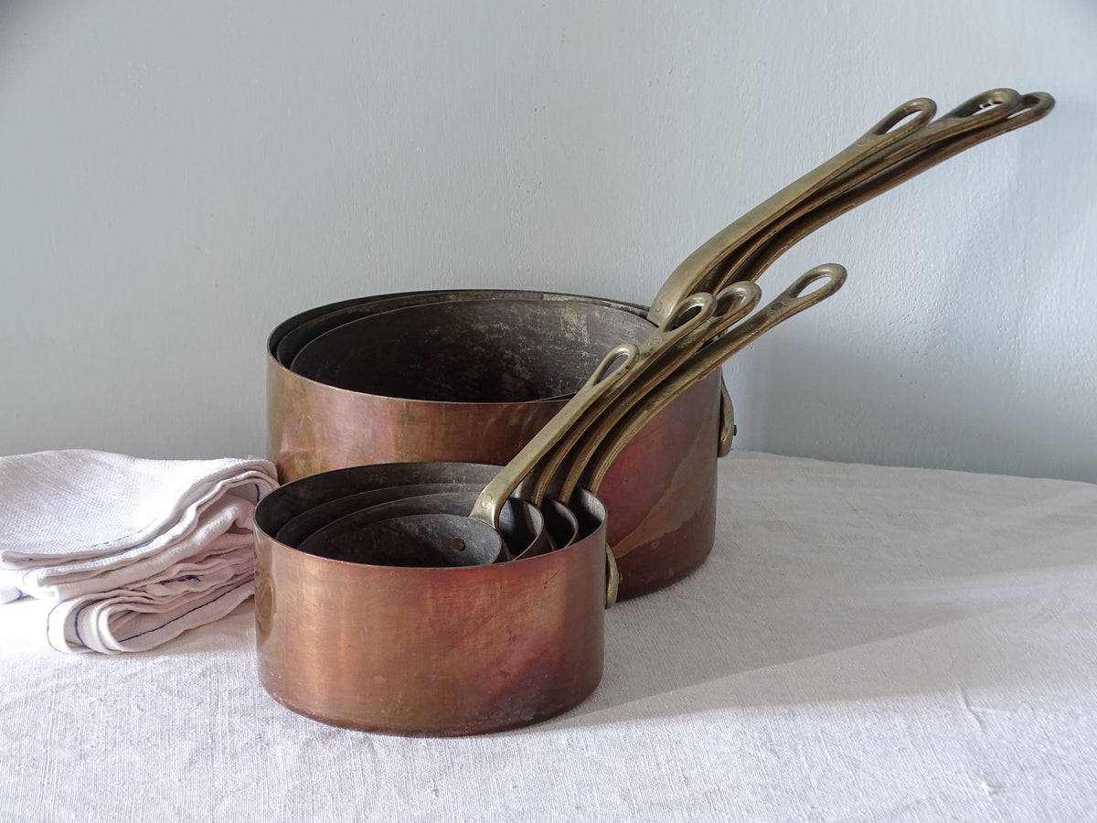 Set of 7 French antique copper pans with brass handles