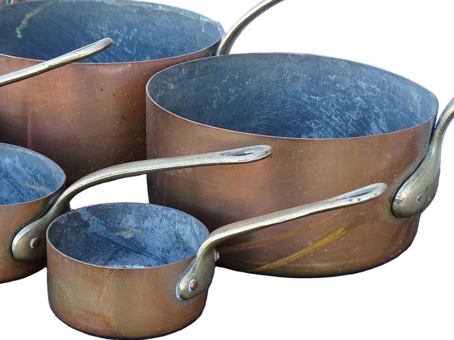 Set of seven French antique copper pans with brass handles. Tinned copper saucepans.