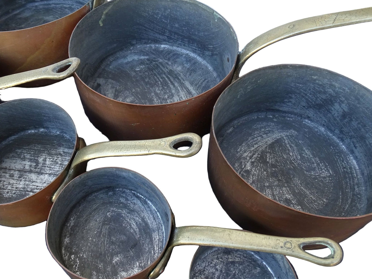 Set of seven French antique copper pans with brass handles. Tinned copper saucepans.