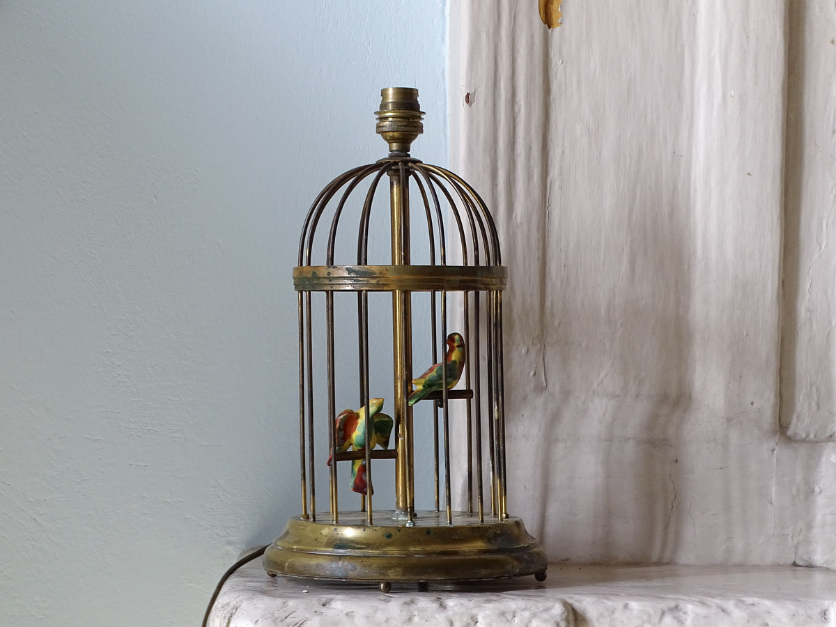 French vintage brass birdcage lamp with porcelain birds, pictured on a country house fireplace
