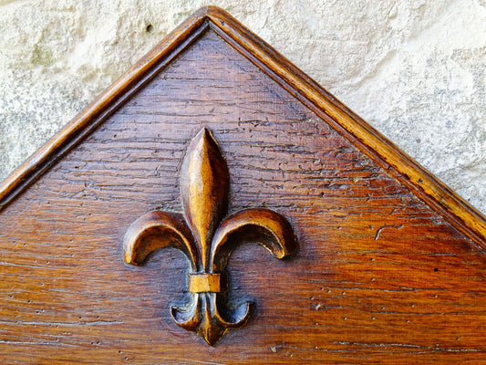 French antique wooden mirror topped with a triangular pediment decorated with a fleur de lis and two turned finial