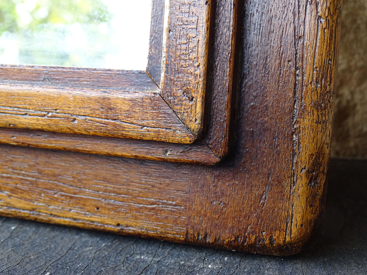 French antique wooden mirror topped with a triangular pediment decorated with a fleur de lis and two turned finial