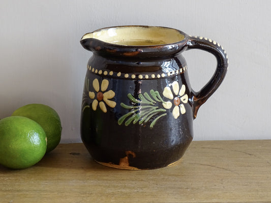 French vintage ceramic pitcher from Alsace. Pottery jug with brown glaze and hand painted with flowers, leaves and dots.