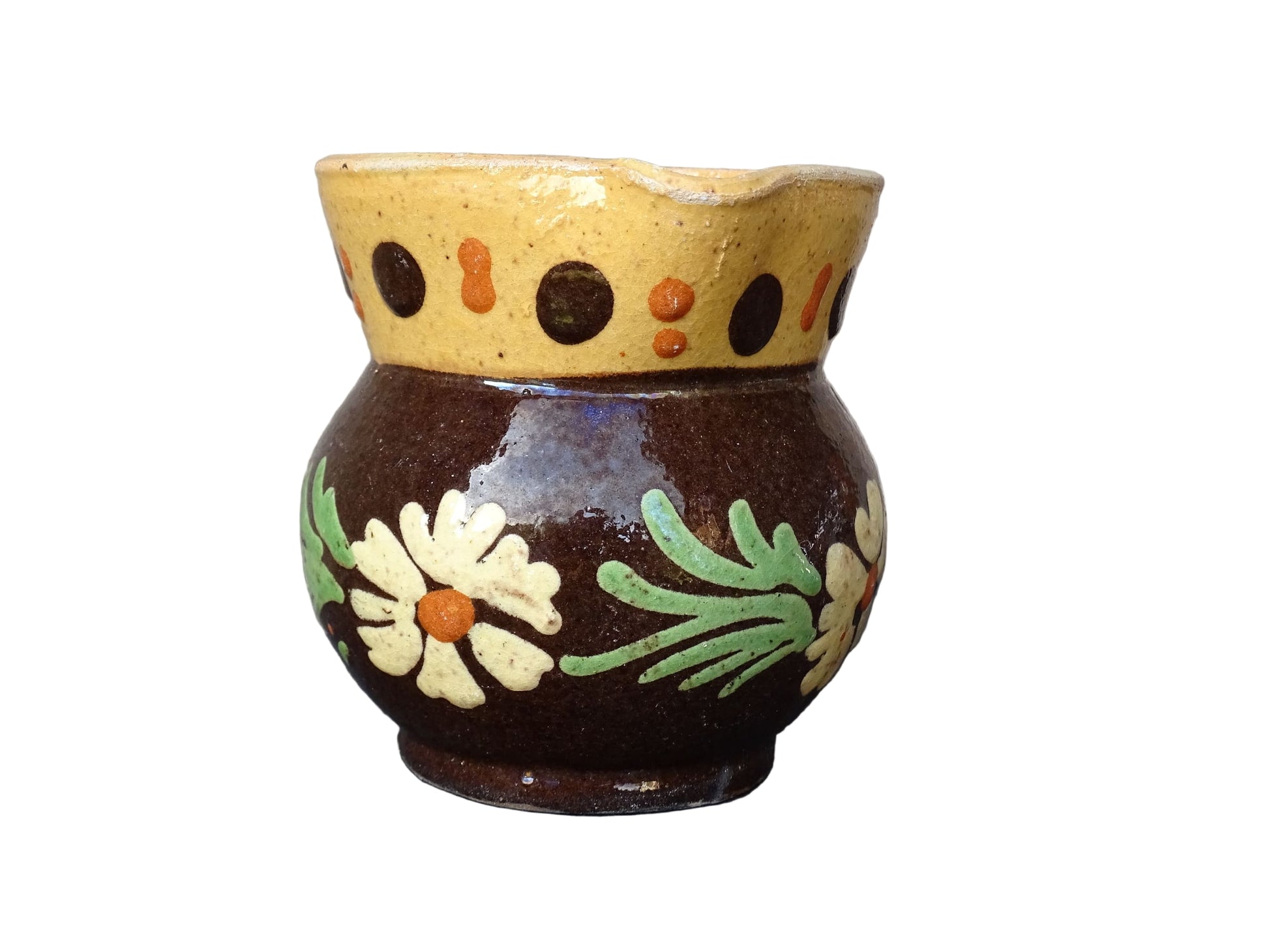 Small French vintage pottery pitcher from Alsace. Ceramic jug with a brown glaze and yellow glazed stripe around the top. It is hand painted with white flowers, green leaves and dots.