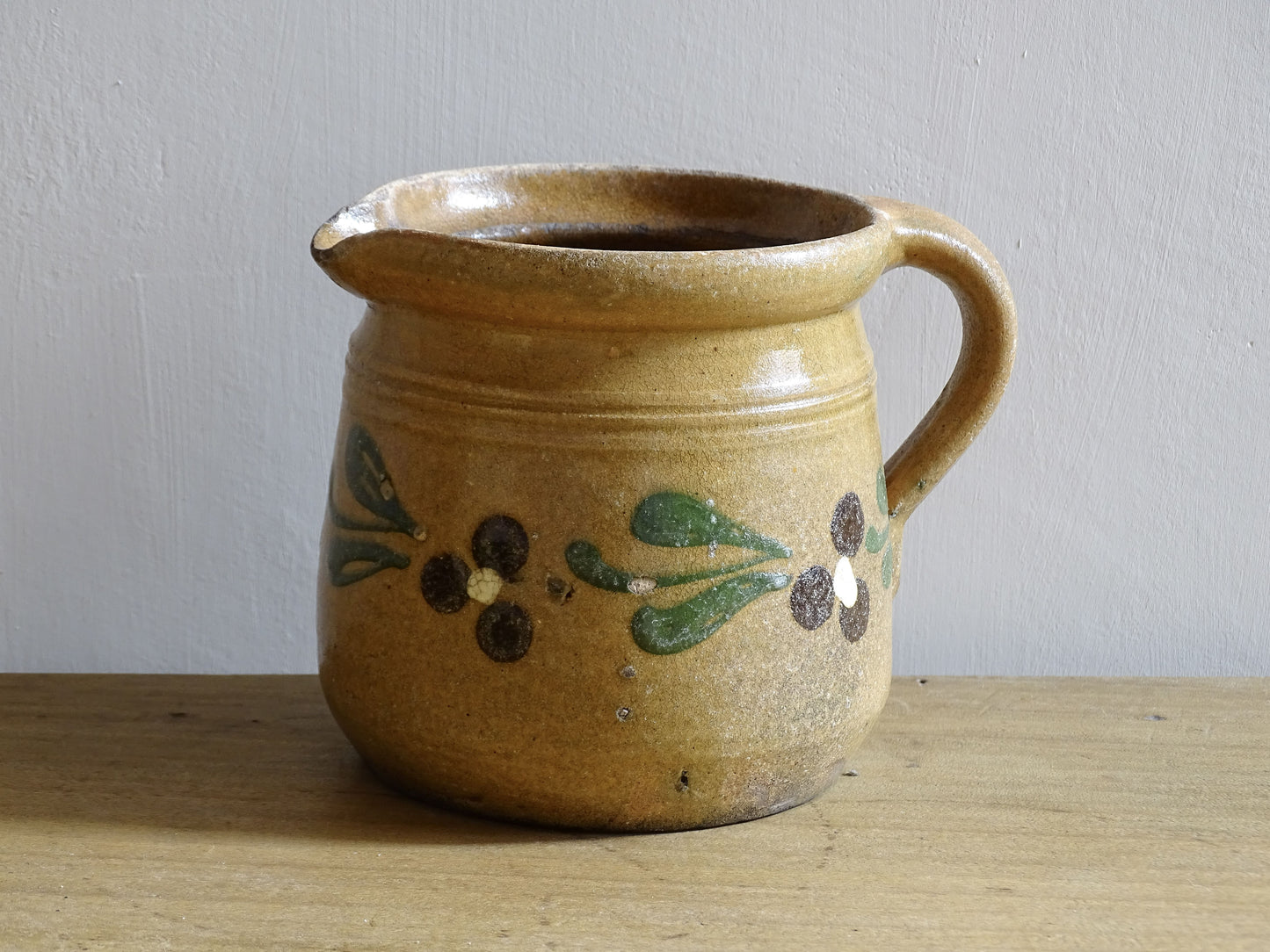Small French vintage pottery jug from Alsace with flowers. Brown glazed ceramic pitcher. 