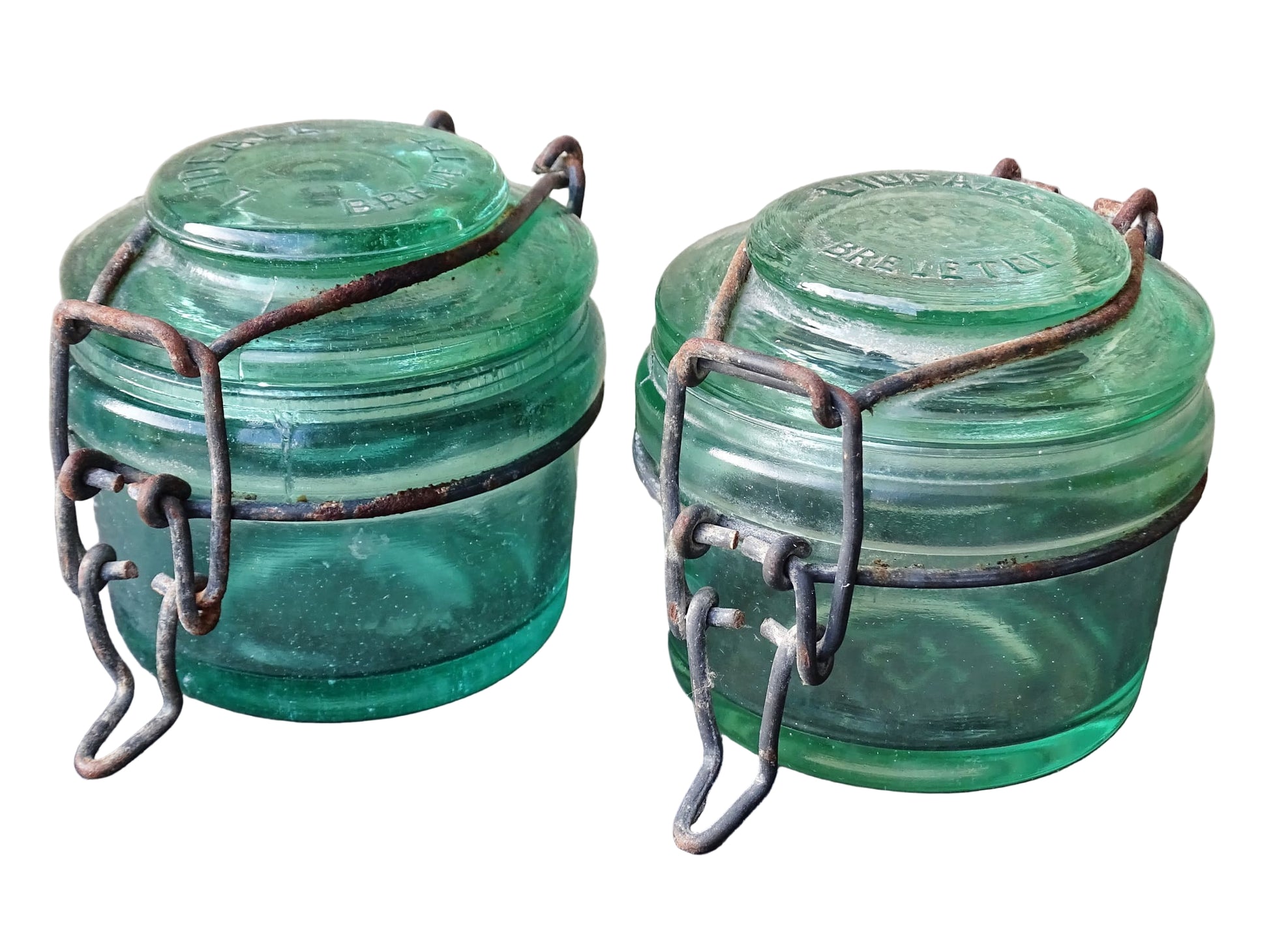 Pair of French vintage green glass preserving jars by L'Ideale. They have thick glass, embossed with the maker's name on top and original metal fasteners with a naturally aged finish. 