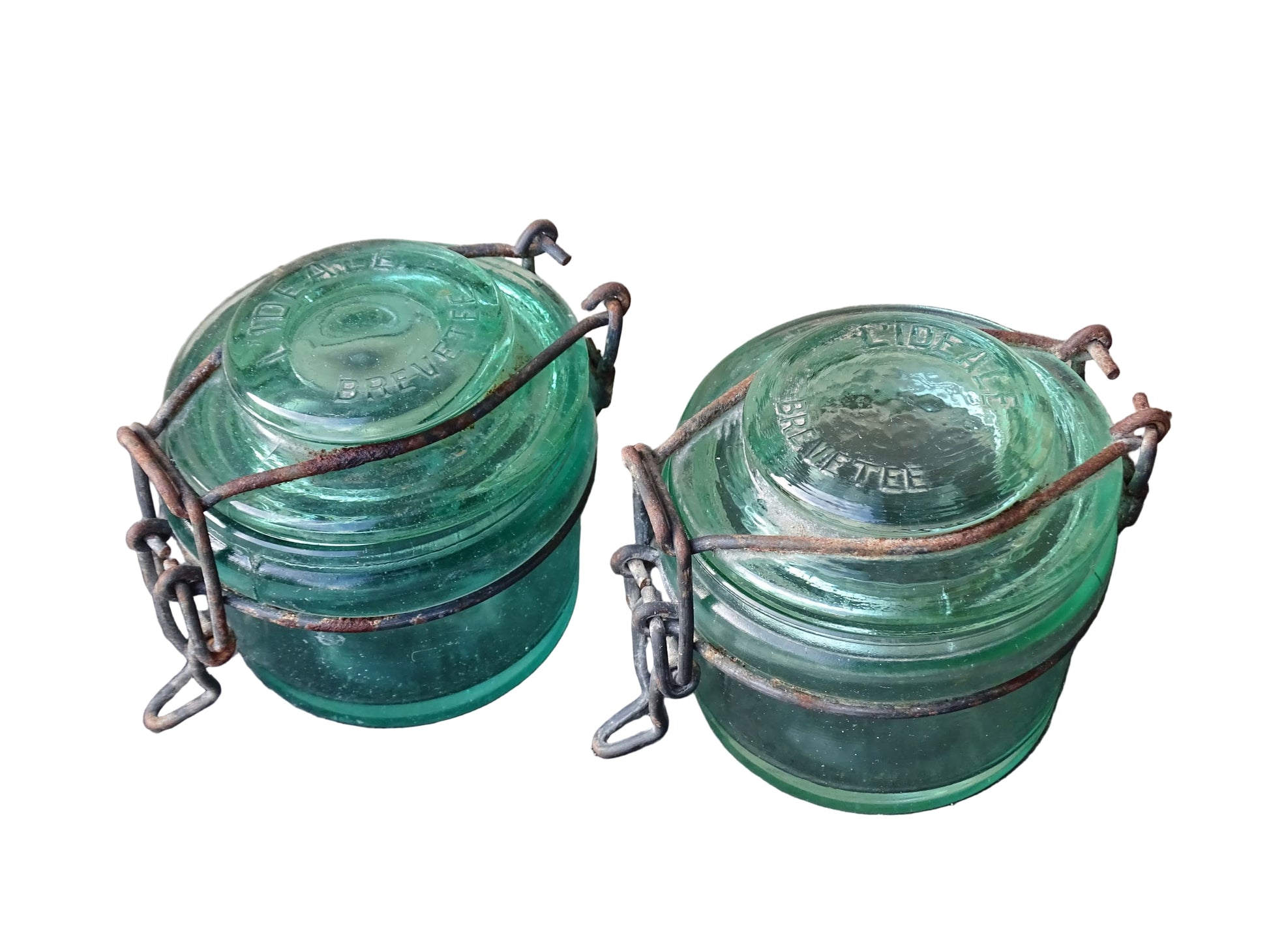 Pair of French vintage green glass preserving jars by L'Ideale. They have thick glass, embossed with the maker's name on top and original metal fasteners with a naturally aged finish. 