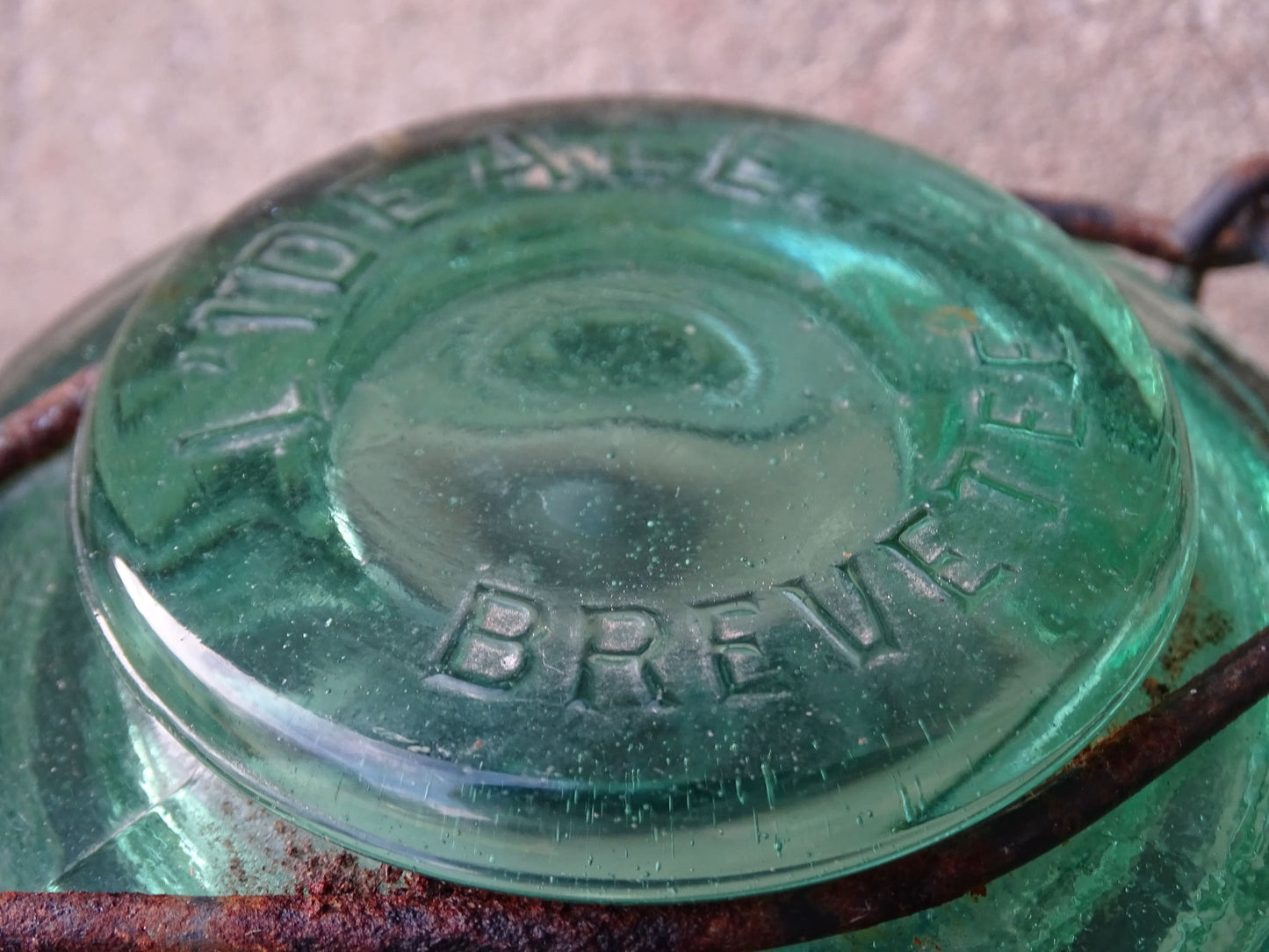 Pair of French vintage green glass preserving jars by L'Ideale. They have thick glass, embossed with the maker's name on top and original metal fasteners with a naturally aged finish. 