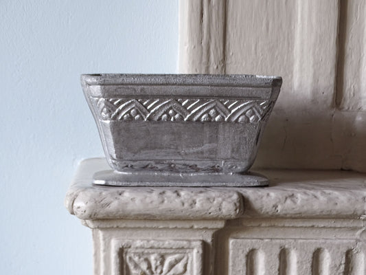 French antique cast iron planter in silver, pictured on a country house fireplace
