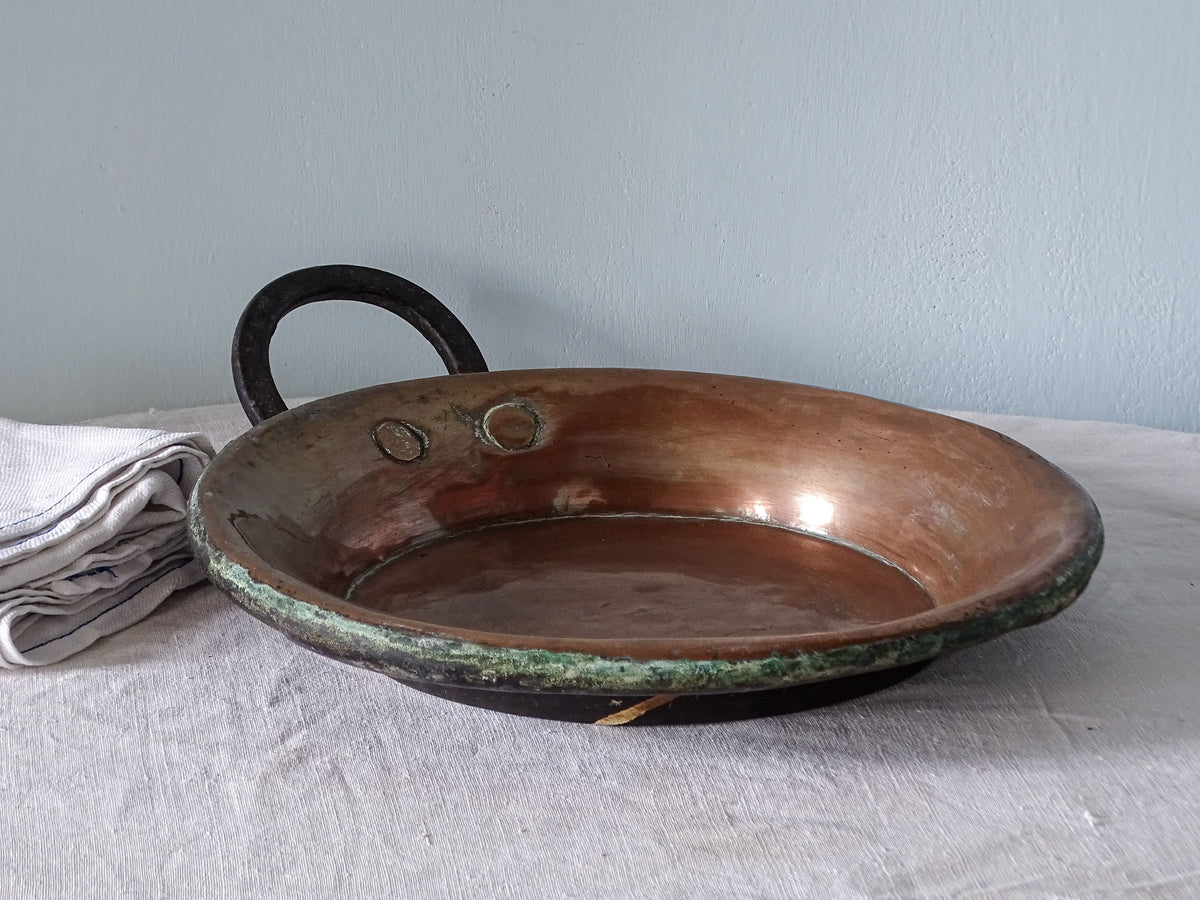 French antique copper pan with wrought iron handle, pictured with antique linen