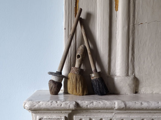 French vintage paint brushes with wooden handles, displayed on a country house fireplace mantel