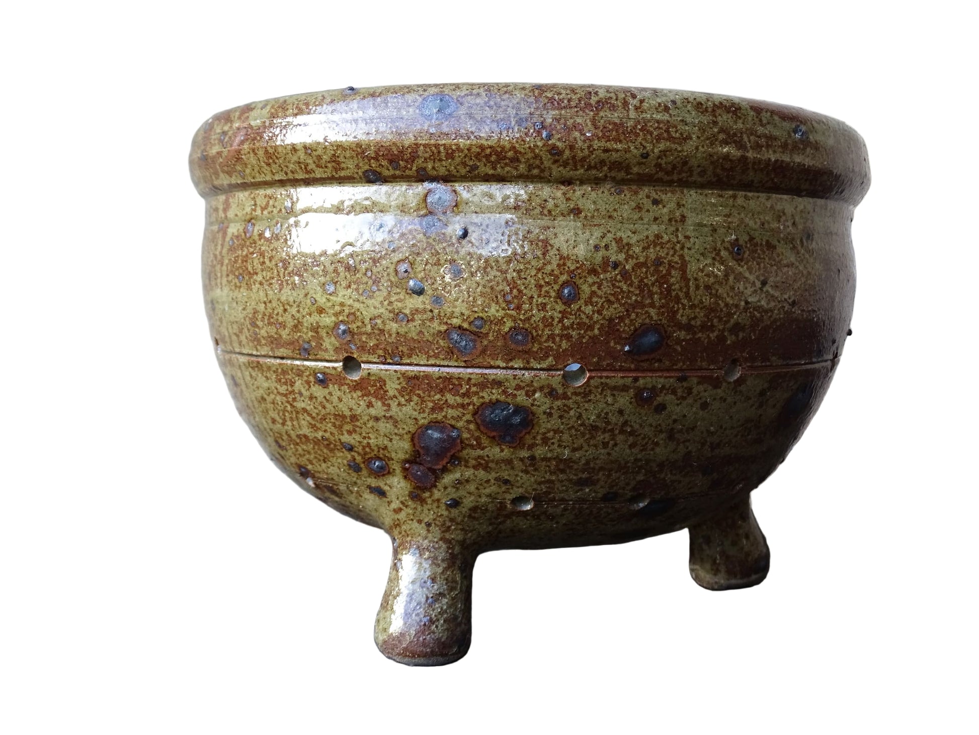 Rustic French vintage ceramic colander, stoneware berry strainer with a speckled glaze. It has a mix of warm earthy browns and olive tones, with darker fleck. It stands on three small feet and has a round form and softly curved rim.