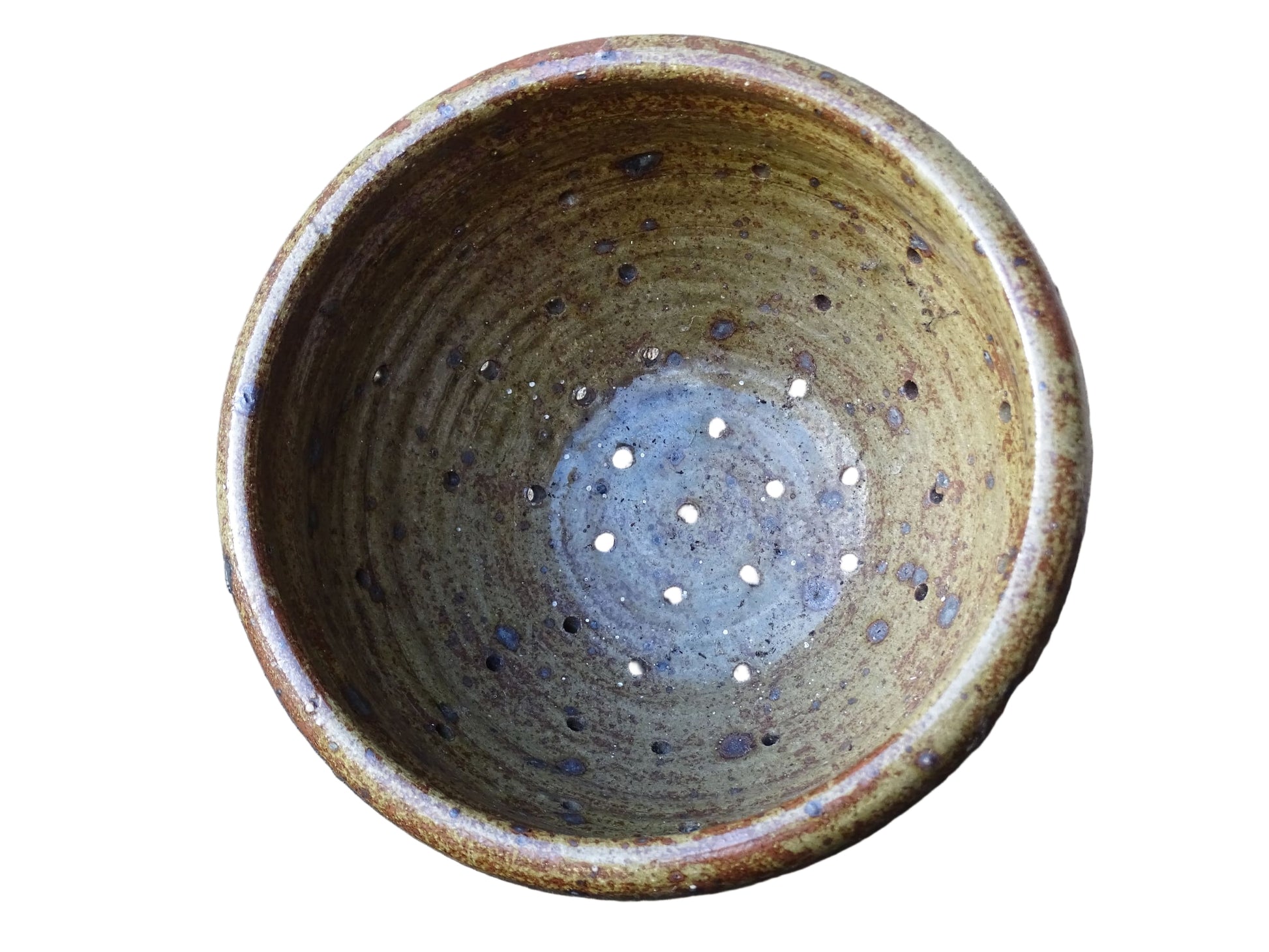 Rustic French vintage ceramic colander, stoneware berry strainer with a speckled glaze. It has a mix of warm earthy browns and olive tones, with darker fleck. It stands on three small feet and has a round form and softly curved rim.