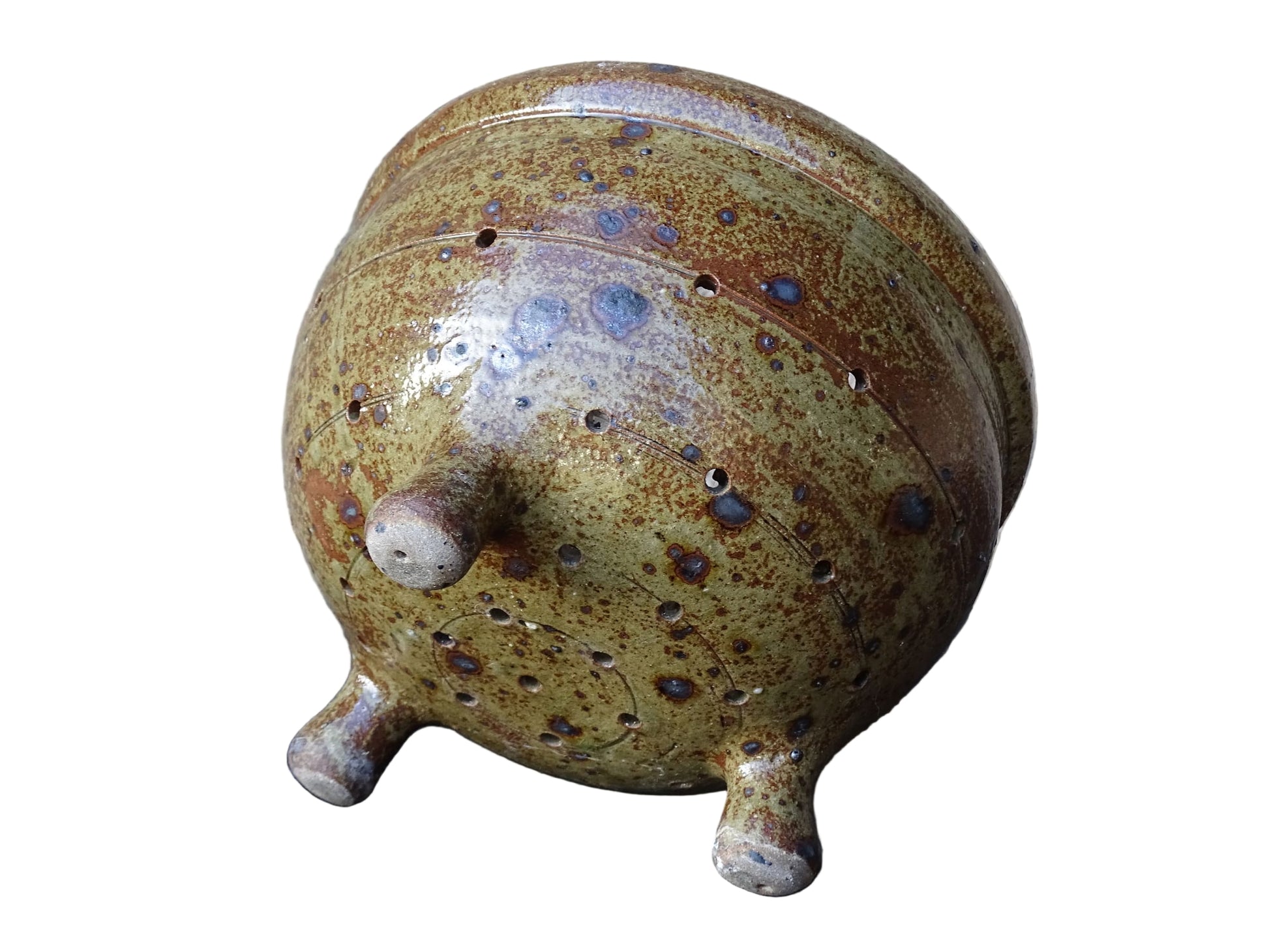 Rustic French vintage ceramic colander, stoneware berry strainer with a speckled glaze. It has a mix of warm earthy browns and olive tones, with darker fleck. It stands on three small feet and has a round form and softly curved rim.