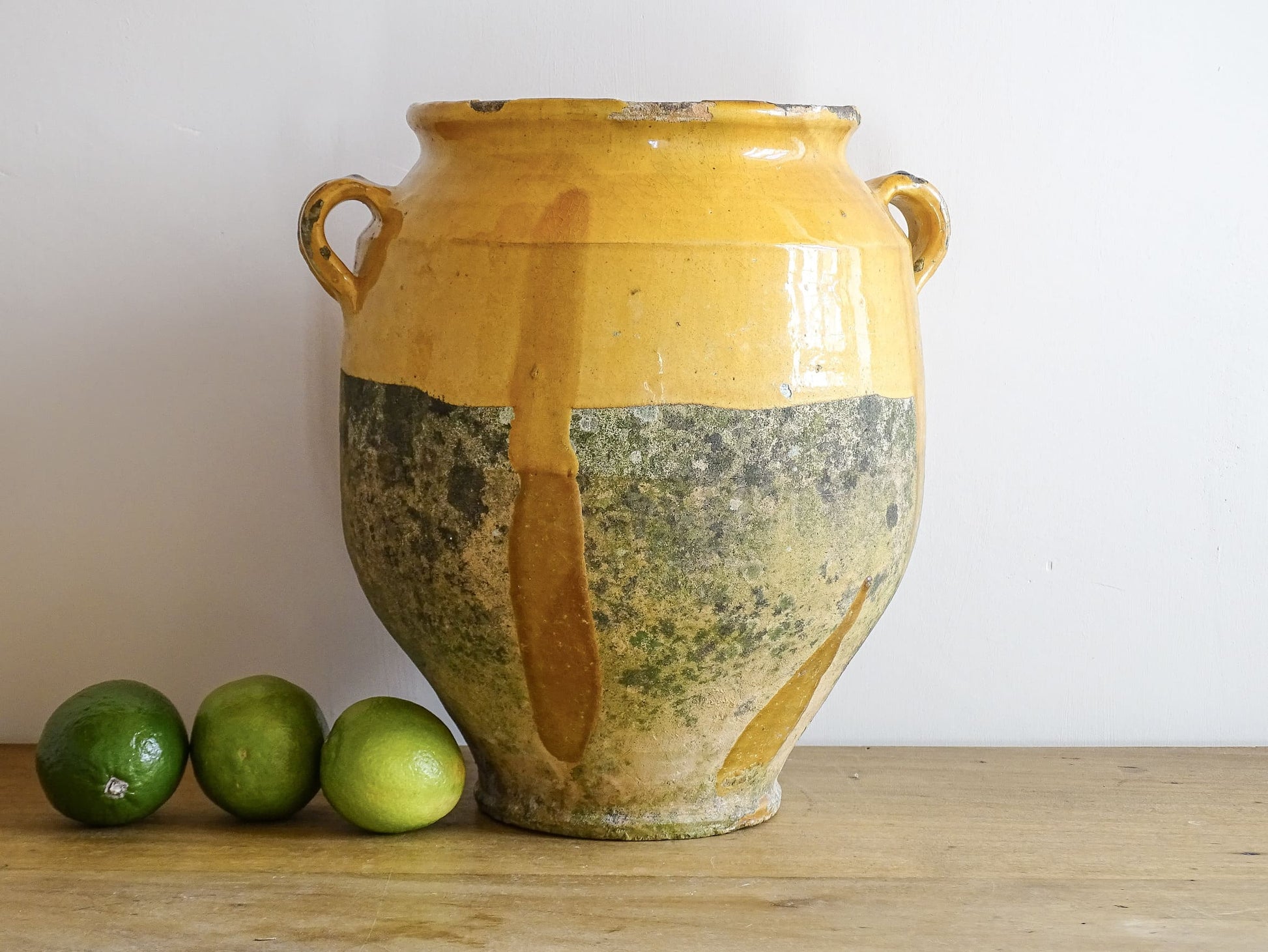 French antique confit pot with mustard yellow glaze. Terracotta jar with two handles. 
