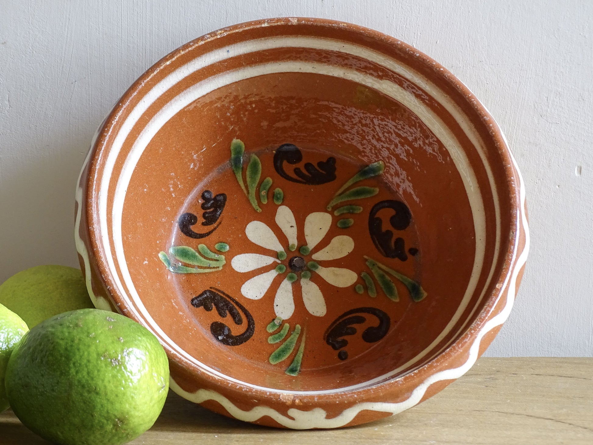 French vintage pottery bowl from Alsace. Glazed terracotta dish with painted flowers.