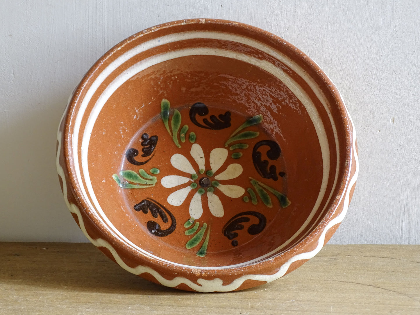 French vintage pottery bowl from Alsace. Glazed terracotta dish with painted flowers.