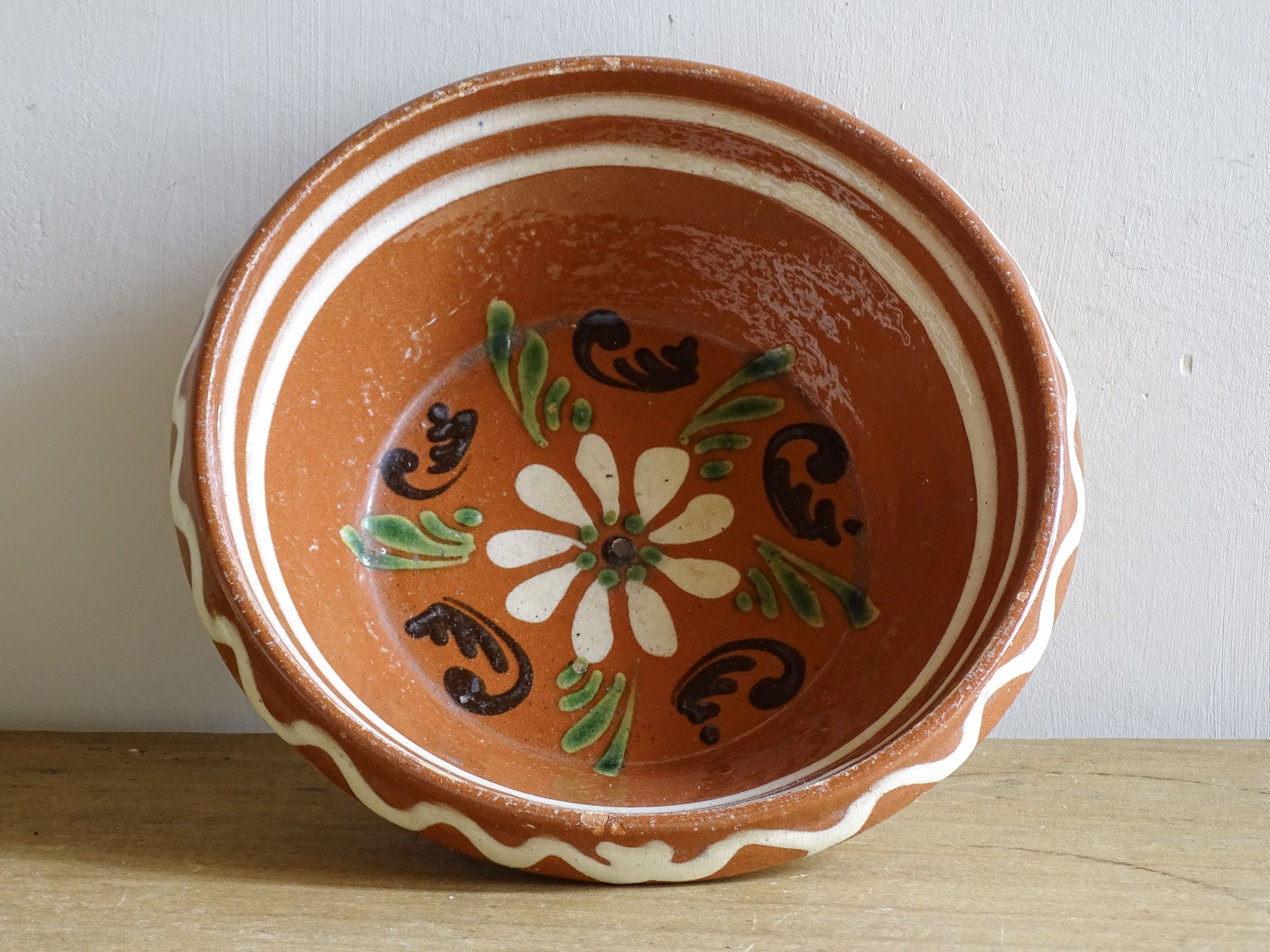 French vintage pottery bowl from Alsace. Glazed terracotta dish with painted flowers.