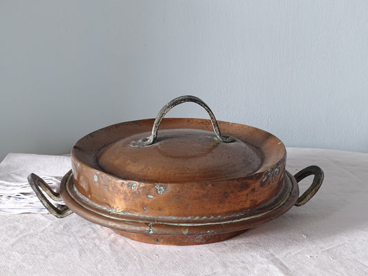 French antique copper tourtiere pan, pictured with antique linen in front of pale blue wall