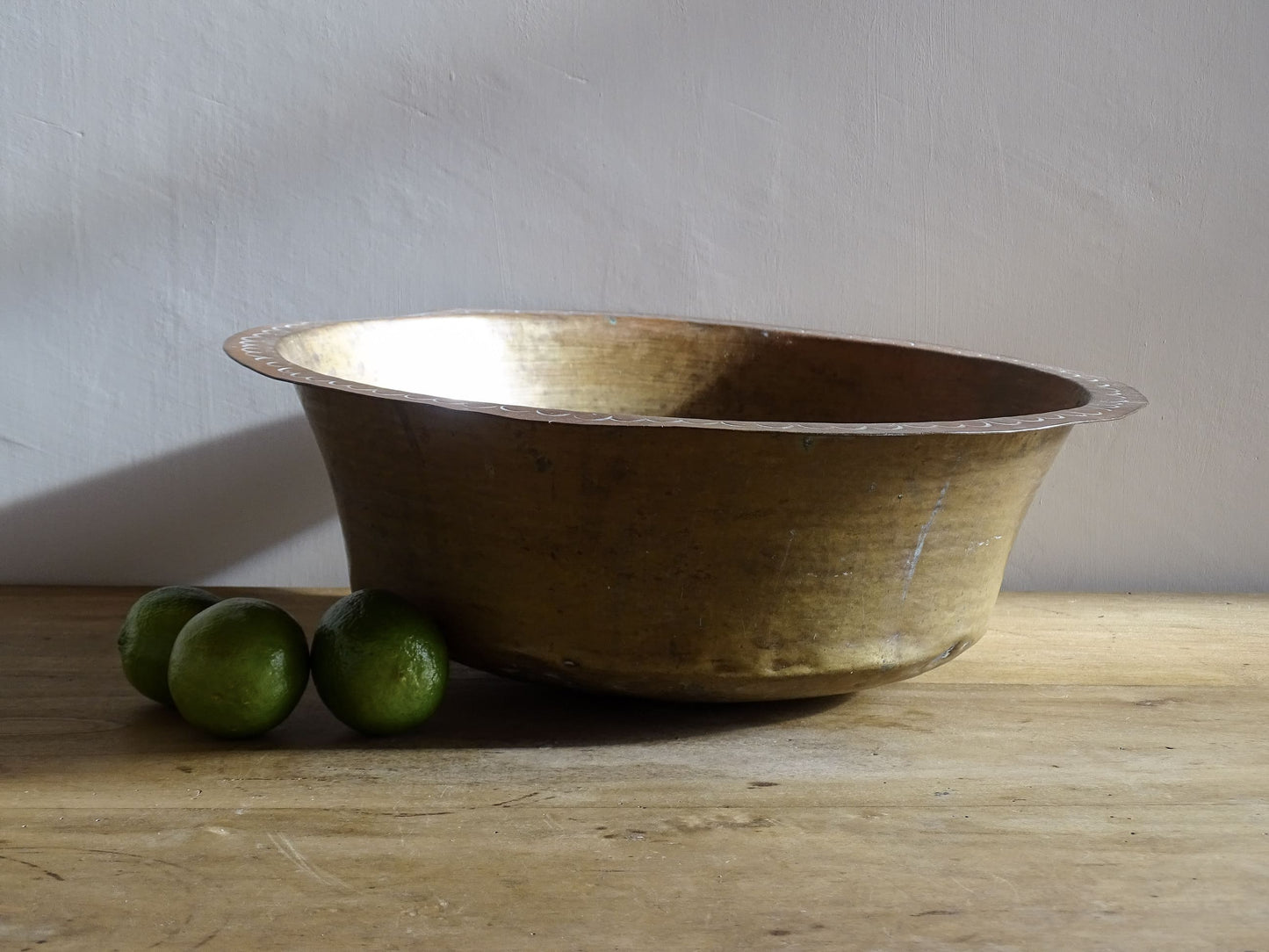 A  timeworn French antique copper bowl with hammered detailing to the rim and a rounded base. This copper bowl has a beautiful, aged patina. 