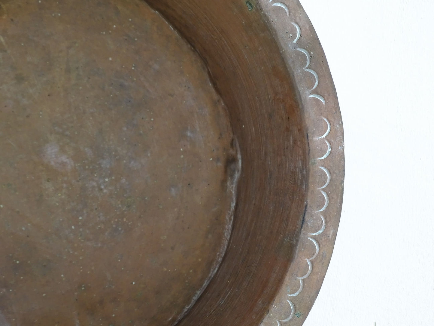A  timeworn French antique copper bowl with hammered detailing to the rim and a rounded base. This copper bowl has a beautiful, aged patina. 