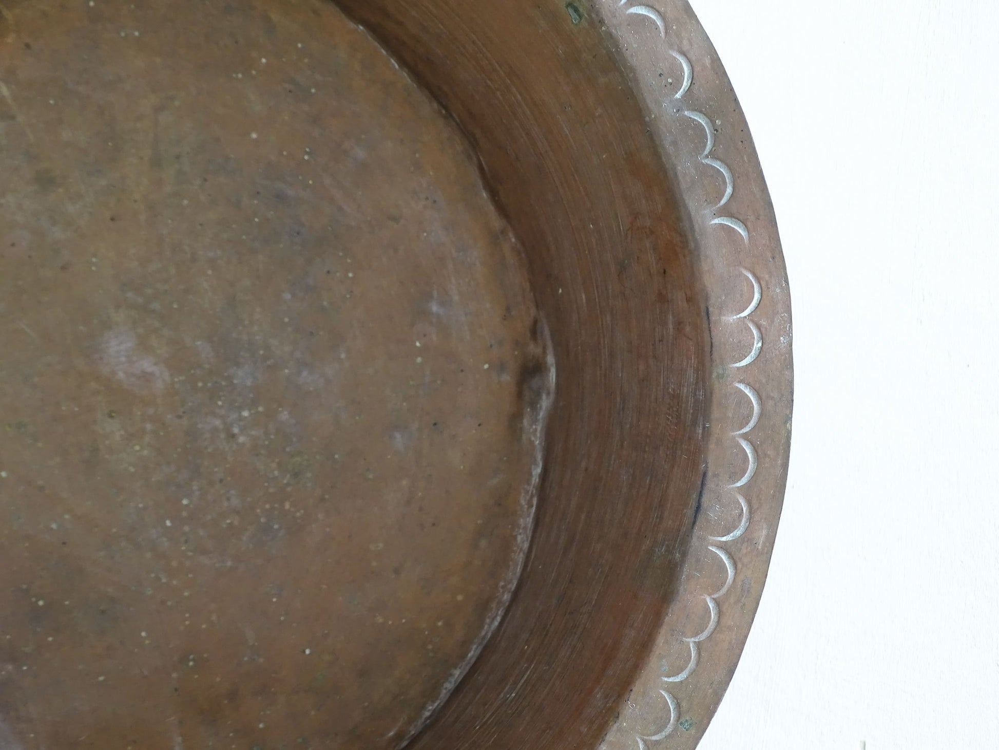A  timeworn French antique copper bowl with hammered detailing to the rim and a rounded base. This copper bowl has a beautiful, aged patina. 