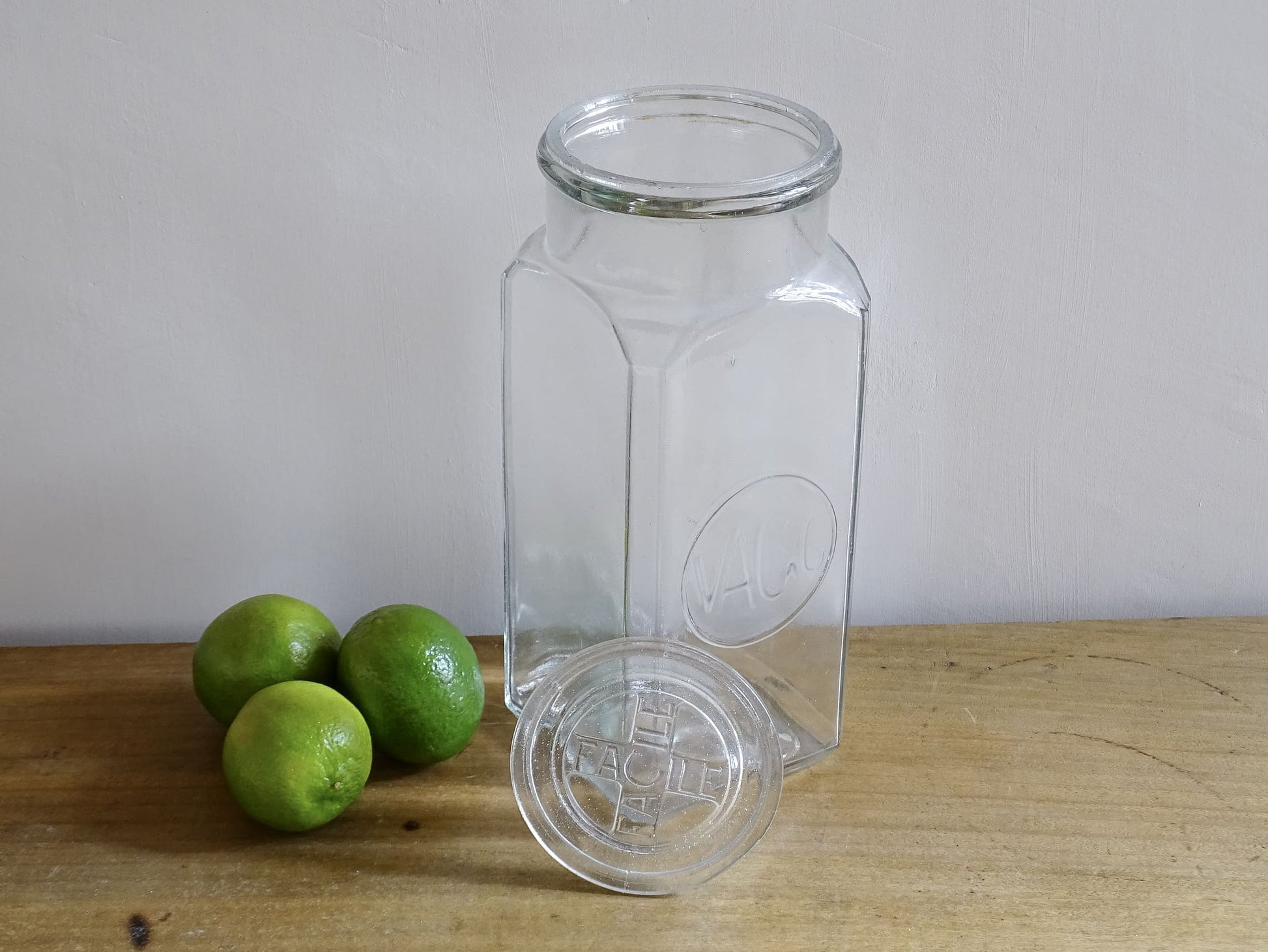 A French antique glass épicerie jar with original lid. Dating to circa 1920. It is made beautiful, thick pressed glass, embossed with the maker's name to the front and "Facile" to the top of the lid. 