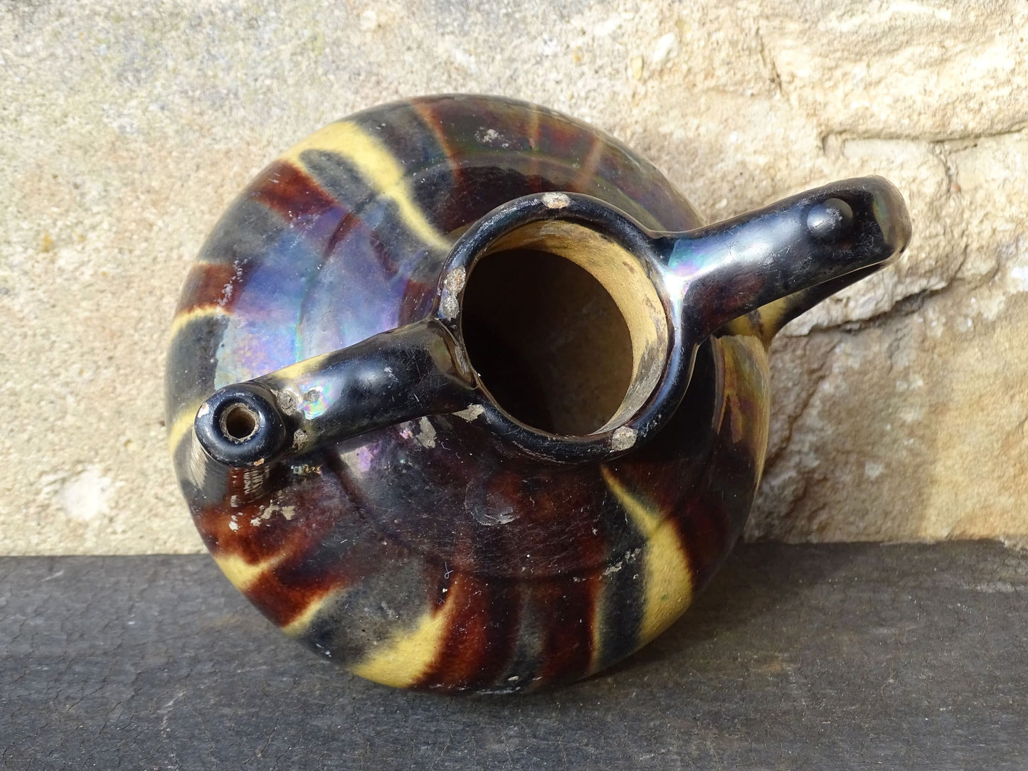 French antique ceramic jug or orjol with striped glaze. Glazed terracotta pitcher with yellow, black and brown glaze. 