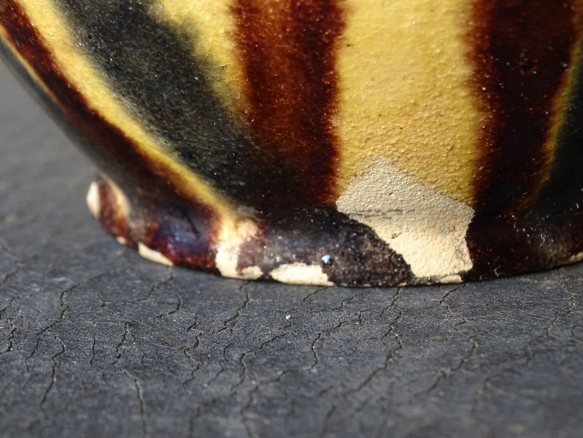 French antique ceramic jug or orjol with striped glaze. Glazed terracotta pitcher with yellow, black and brown glaze. 