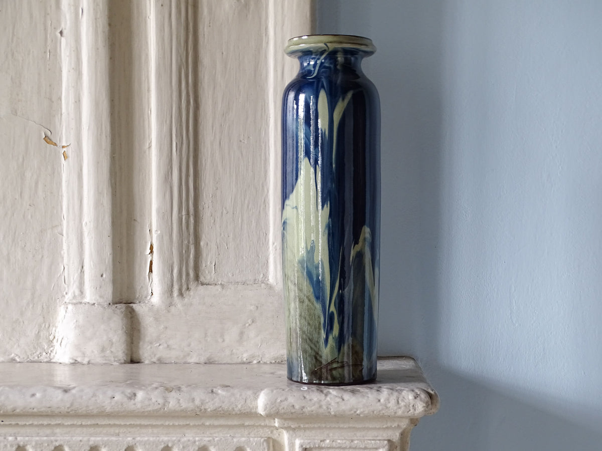 Vintage ceramic vase with blue glaze displayed on a French country fireplace