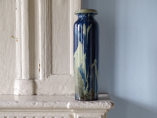 Vintage ceramic vase with blue glaze displayed on a French country fireplace