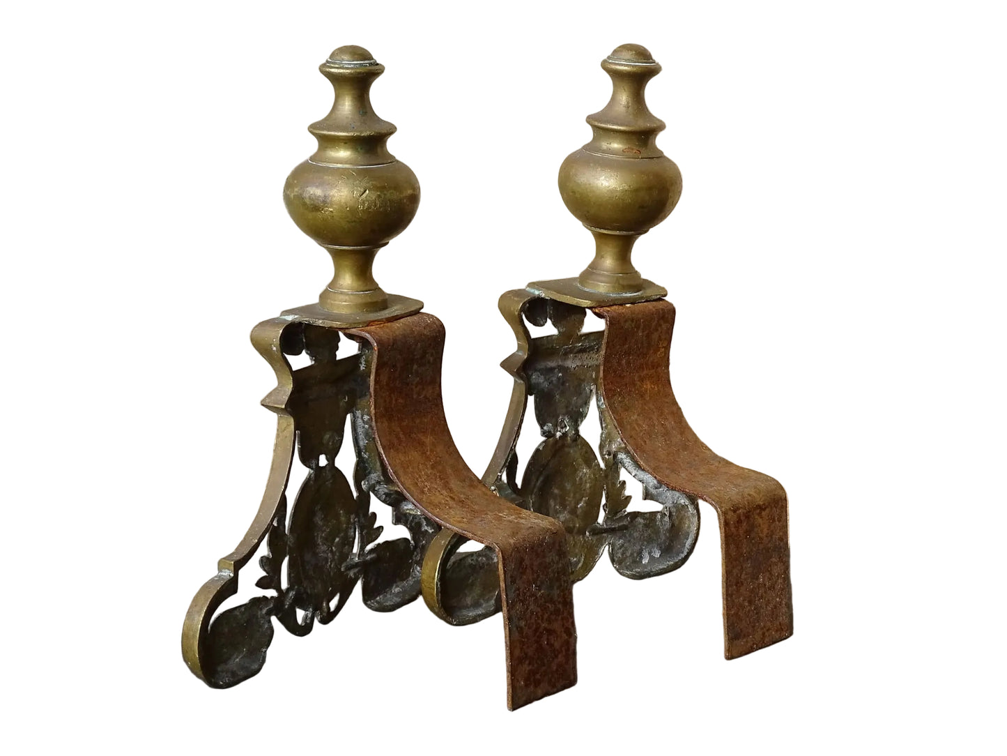 Pair of French antique brass andirons or fire dogs in a Louis XVI revival style. Each andiron is topped with a turned baluster finial. The pierced front plates display an ornate composition of acanthus leaves, scrollwork, and a central oval cartouche framed by laurel branches, typical of neoclassical design.