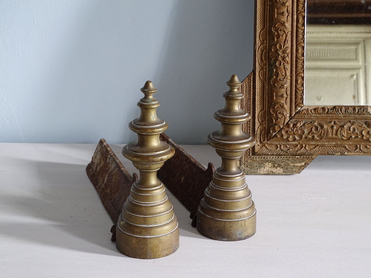 French antique brass andirons with finials, pictured with gold mirror