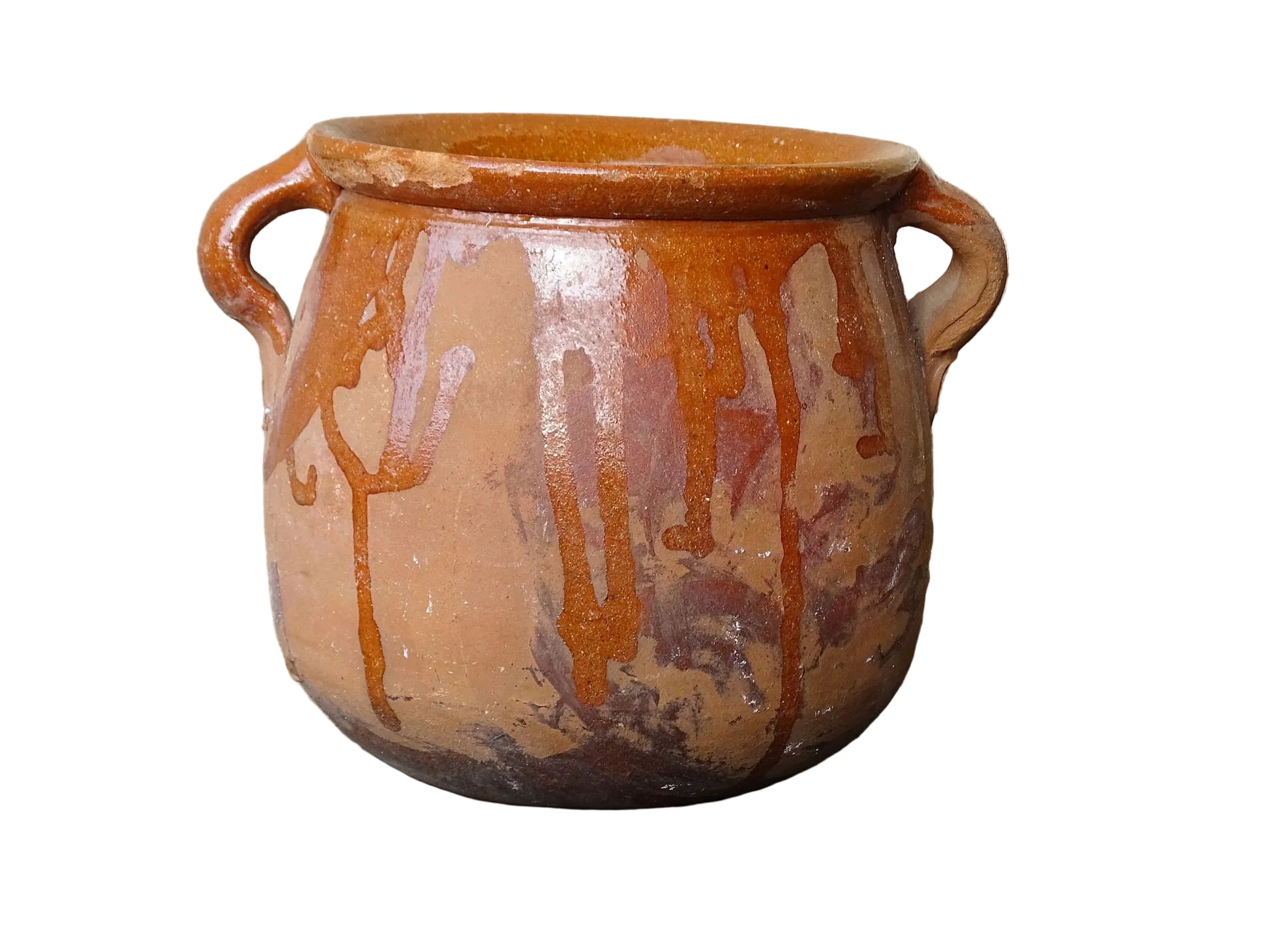 French vintage terracotta pot with orange glaze interior and drip glaze around the sides. Earthenware confit jar with two handles and a curved base.