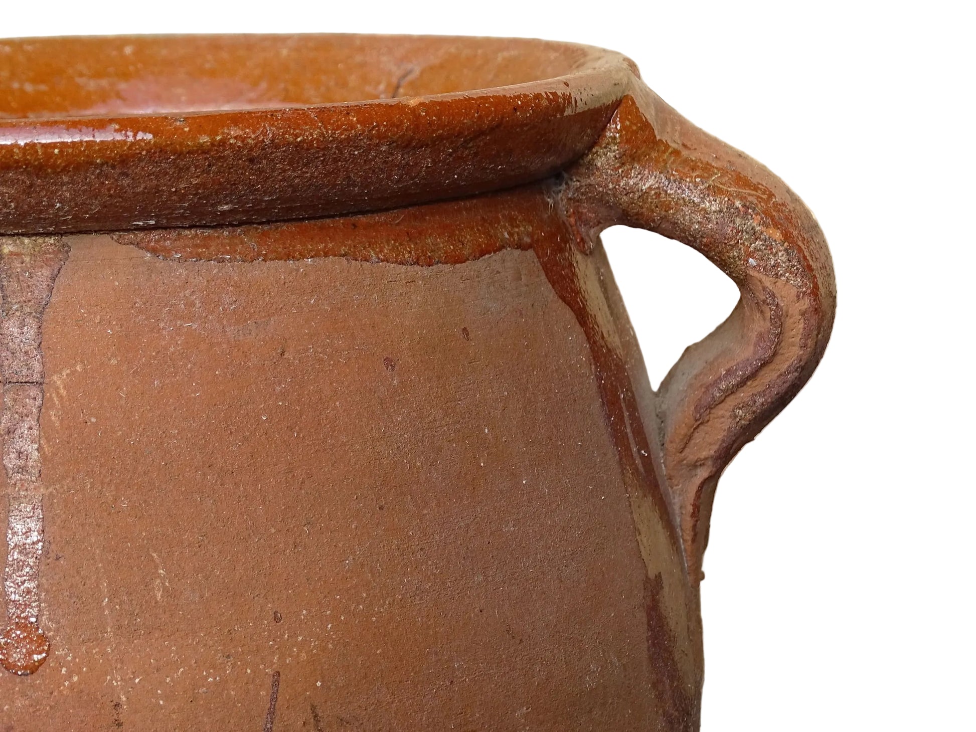French vintage terracotta pot with orange glaze interior and drip glaze around the sides. Earthenware confit jar with two handles and a curved base.