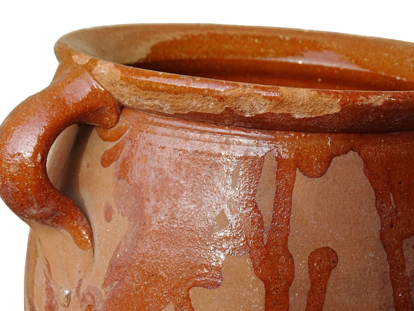 French vintage terracotta pot with orange glaze interior and drip glaze around the sides. Earthenware confit jar with two handles and a curved base.