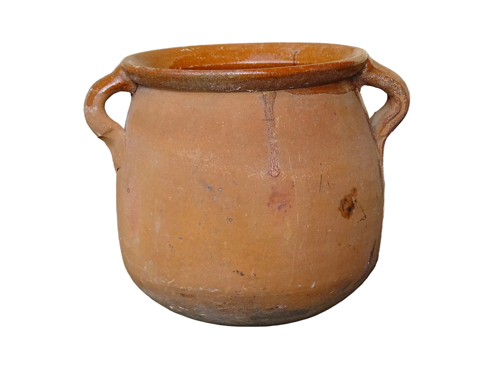 French vintage terracotta pot with orange glaze interior and drip glaze around the sides. Earthenware confit jar with two handles and a curved base.