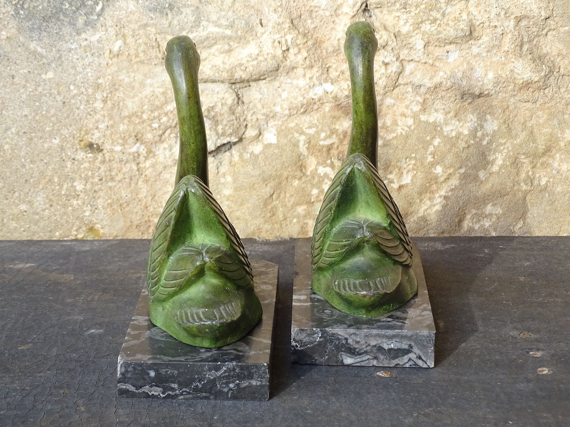 French vintage swan books on black marble bases. The swan statues have a green verdigris effect. 