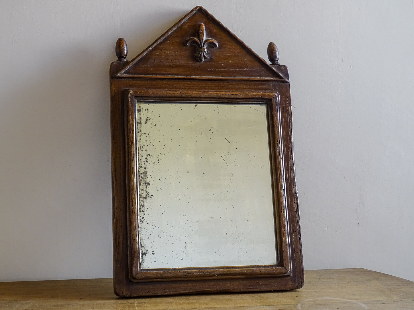 French antique wooden mirror with finials and fleur de lys