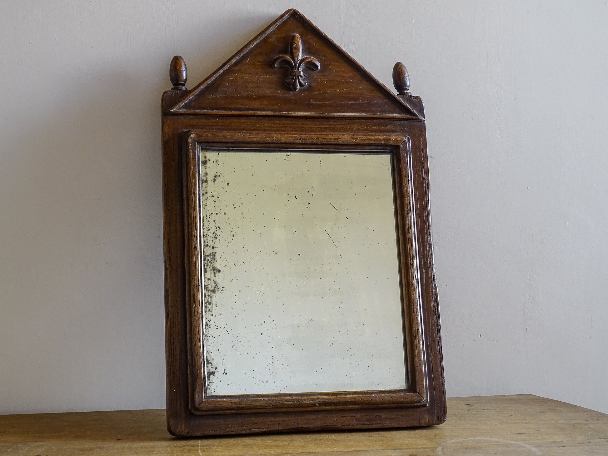 French antique wooden mirror with finials and fleur de lys