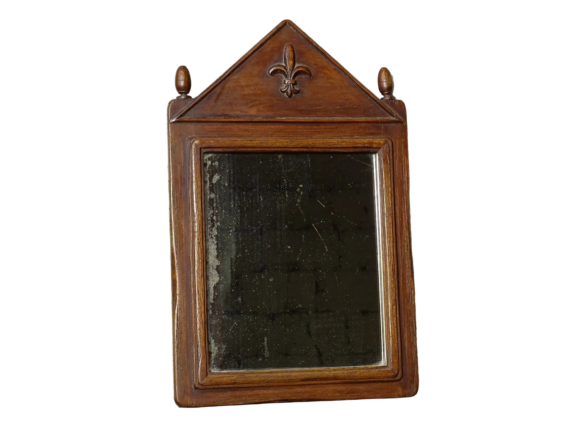 French antique wooden mirror with fleur de lis motif. The wood mirror is topped by a pediment with two turned finials.