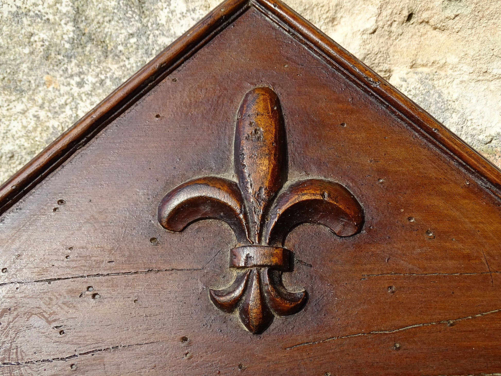 French antique wooden mirror with fleur de lis motif. The wood mirror is topped by a pediment with two turned finials.