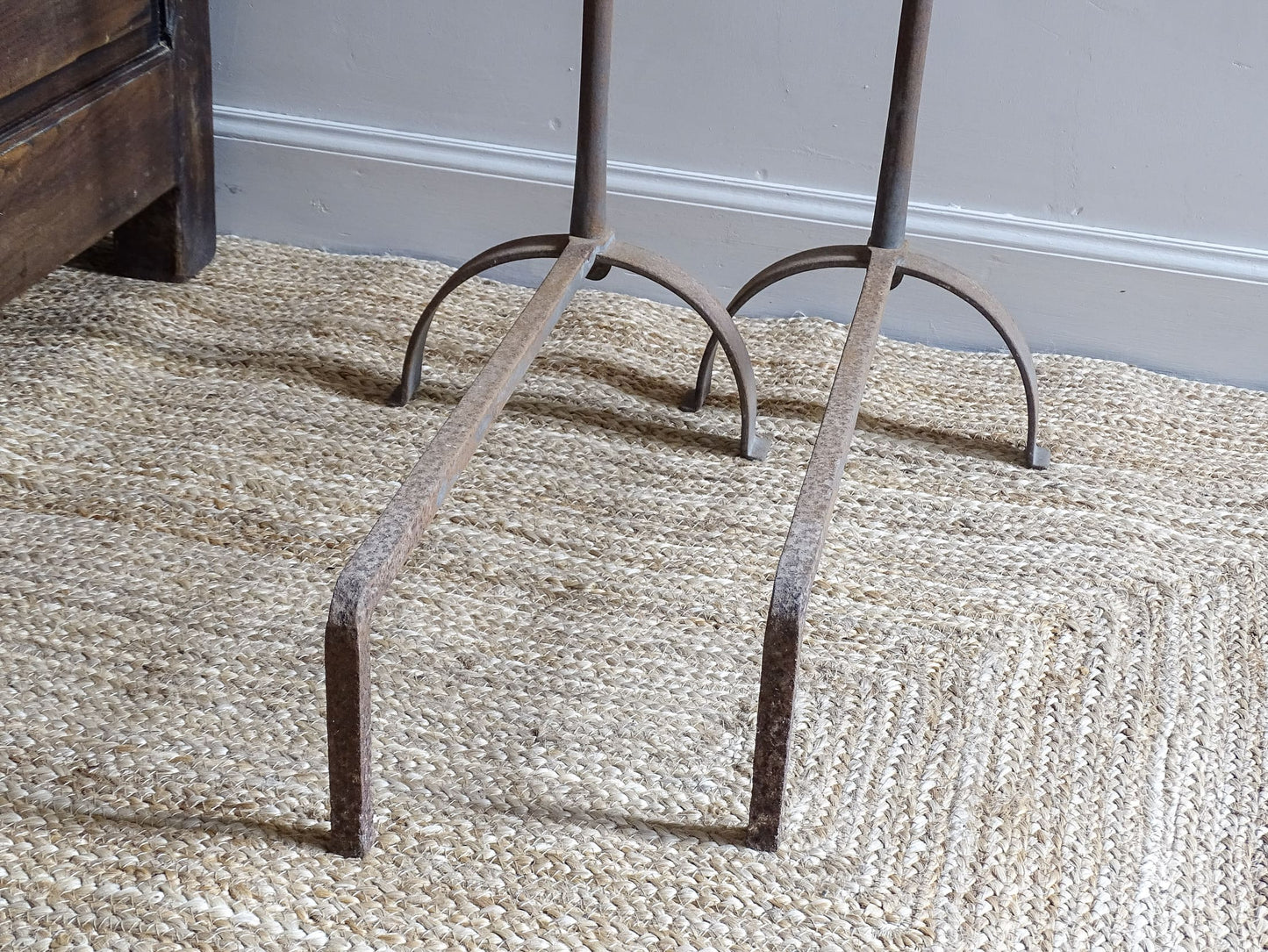 Pair of French antique cast iron andirons or fire dogs, dating to the 19th century. They are rustically aged. These antique fire dogs have globe finials and have beautifully simple farmhouse aesthetic.