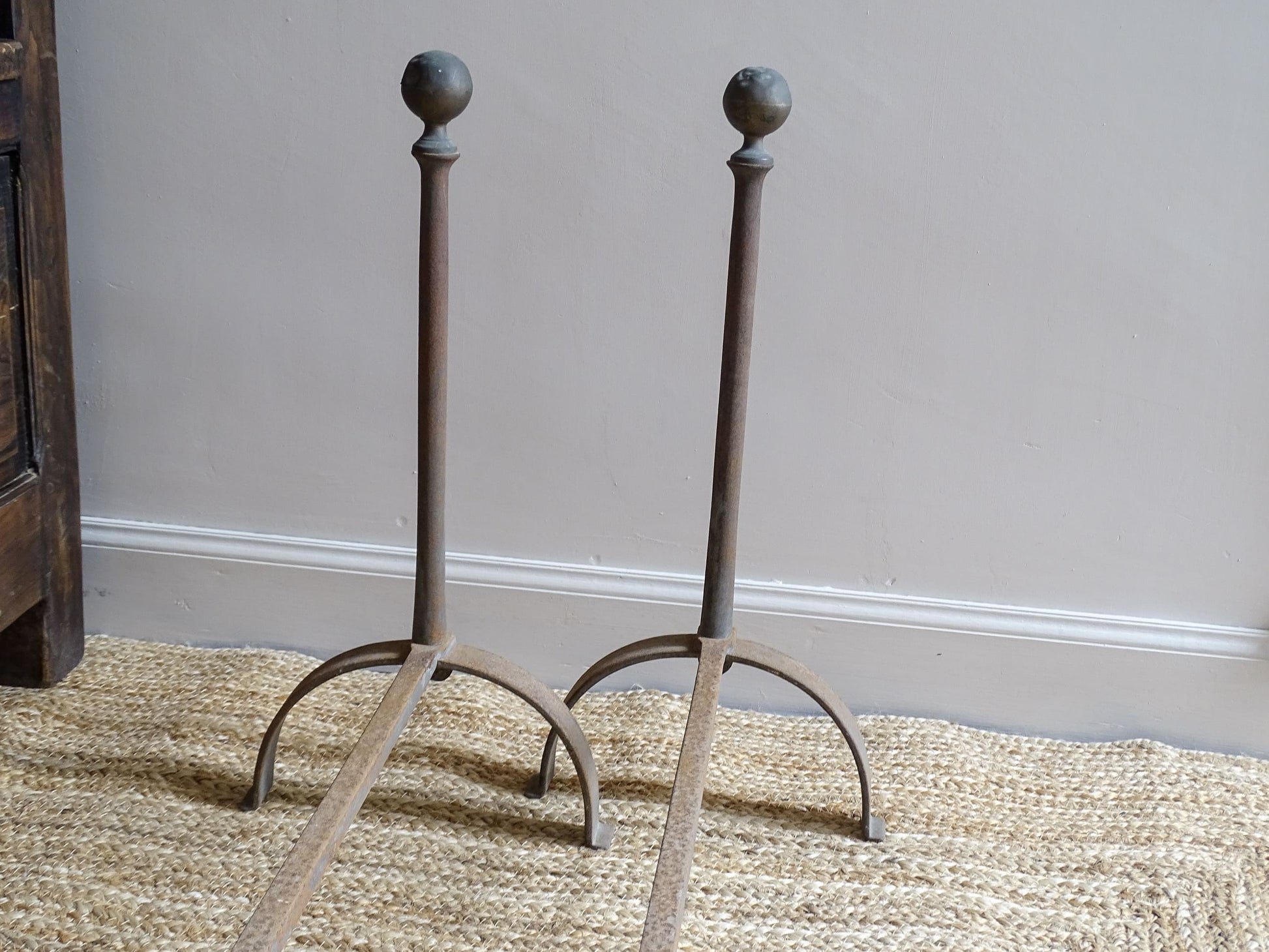 Pair of French antique cast iron andirons or fire dogs, dating to the 19th century. They are rustically aged. These antique fire dogs have globe finials and have beautifully simple farmhouse aesthetic.