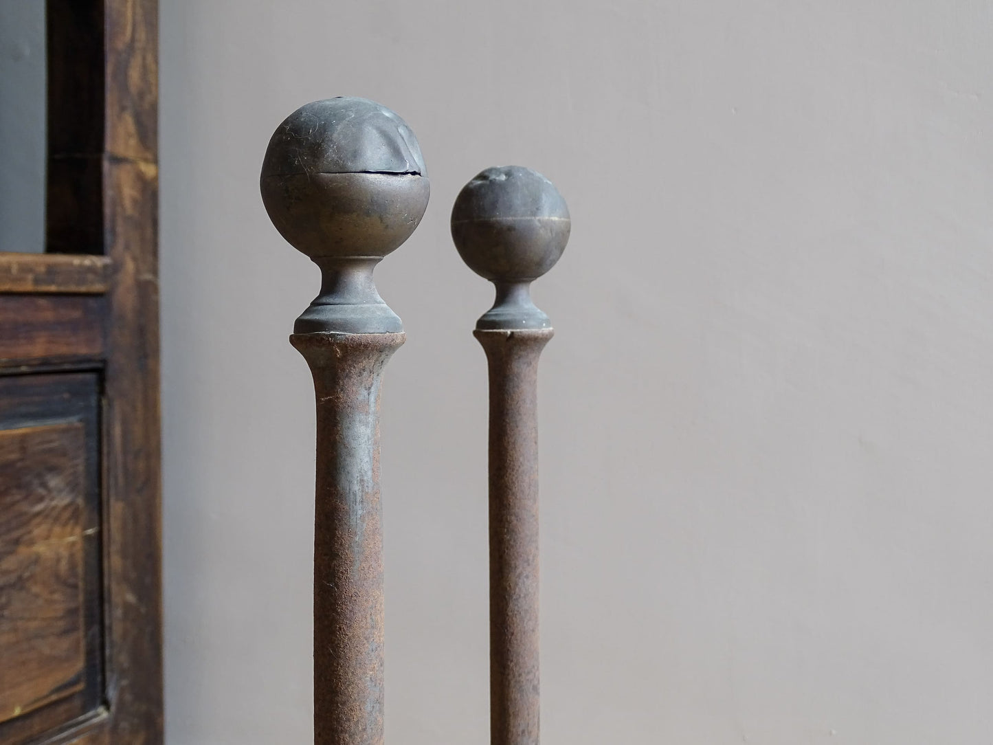 Pair of French antique cast iron andirons or fire dogs, dating to the 19th century. They are rustically aged. These antique fire dogs have globe finials and have beautifully simple farmhouse aesthetic.