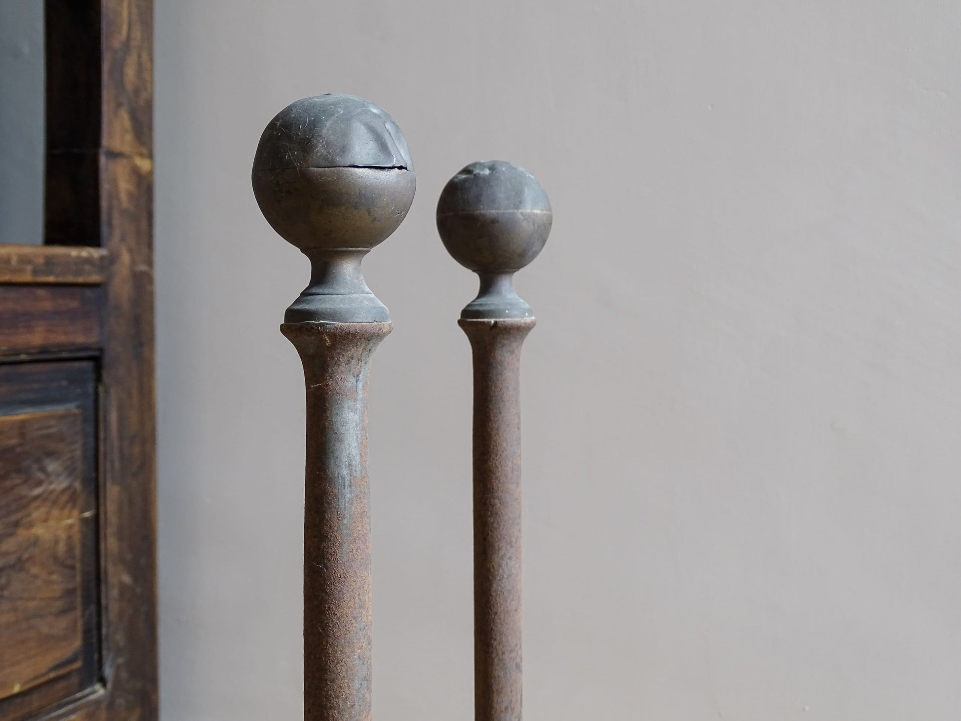 Pair of French antique cast iron andirons or fire dogs, dating to the 19th century. They are rustically aged. These antique fire dogs have globe finials and have beautifully simple farmhouse aesthetic.