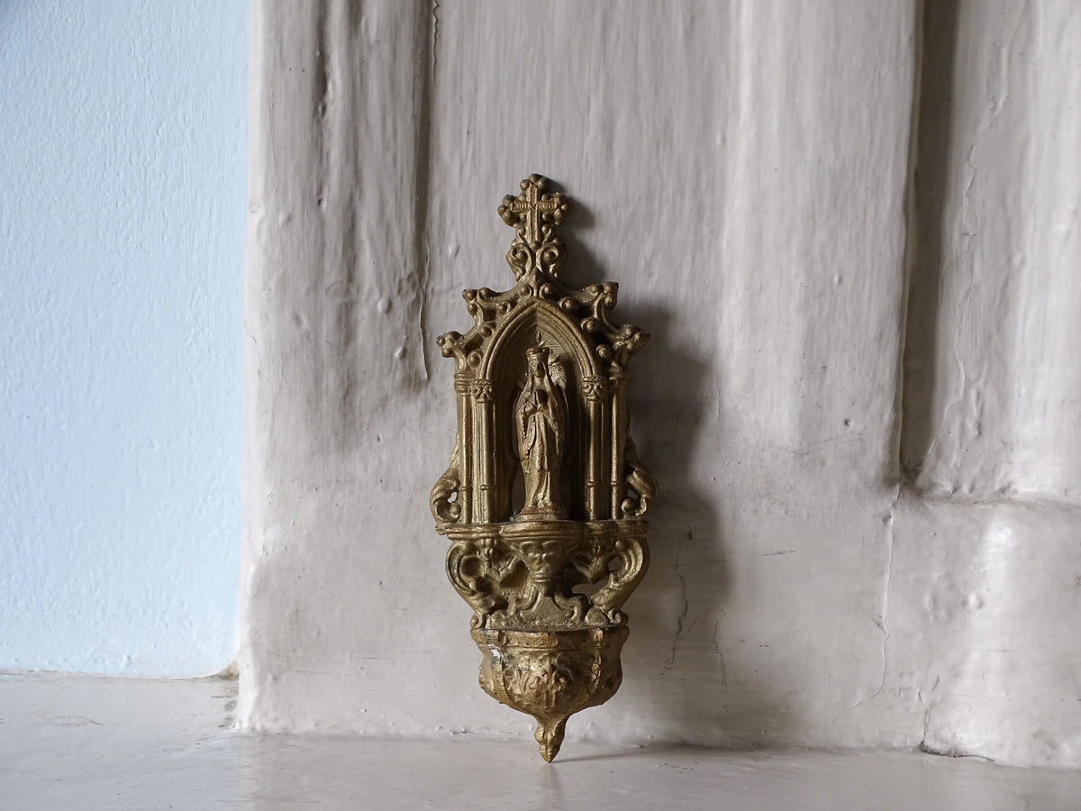 French antique holy water font with the Virgin Mary, displayed on a country house fireplace
