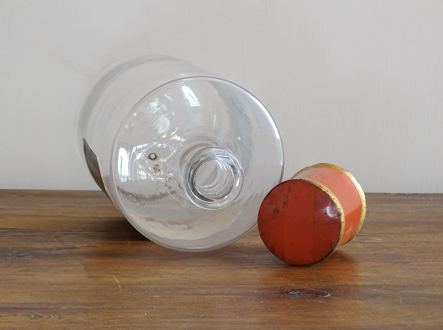 A French antique glass apothecary bottle with original, red and gold, painted metal top and original paper label. The label reads: Eau de Chaux (Lime Water). This antique glass bottle is hand blown and dates to the late 1800's. 