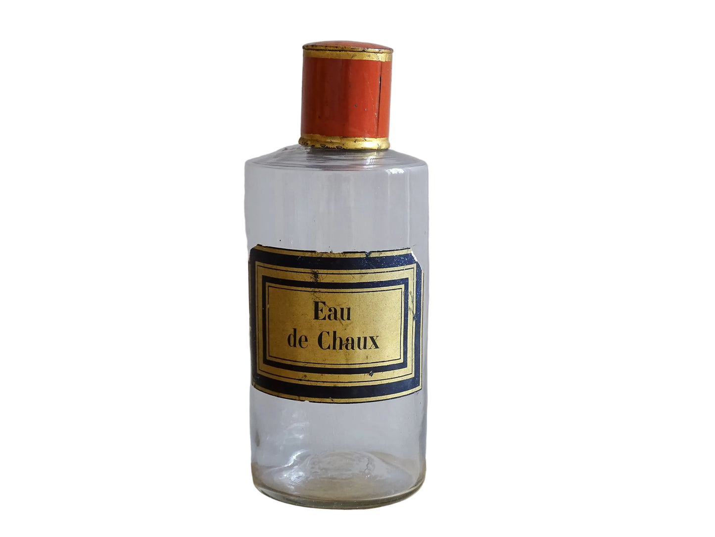 A French antique glass apothecary bottle with original, red and gold, painted metal top and original paper label. The label reads: Eau de Chaux (Lime Water). This antique glass bottle is hand blown and dates to the late 1800's. 