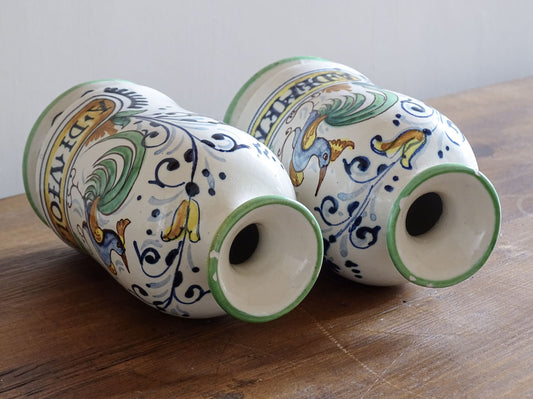 A pair of Italian Antique pharmacy jars dating to circa 1920. These tin-glazed, earthenware jars are decorative in the Renaissance revival tradition. They are painted with colourful cockerels and scrolling foliage.